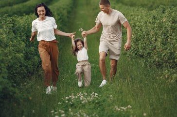 Joyful family enjoying a fun day outdoors in a green field, epitomizing togetherness and happiness.