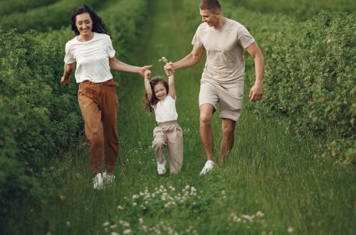 Joyful family enjoying a fun day outdoors in a green field, epitomizing togetherness and happiness.