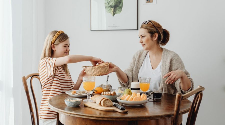 A warm family breakfast with mother and daughter sharing a meal in a cozy dining area.